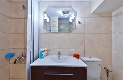 a bathroom with a sink and a toilet and a mirror at Aphrodite House in Chania Town
