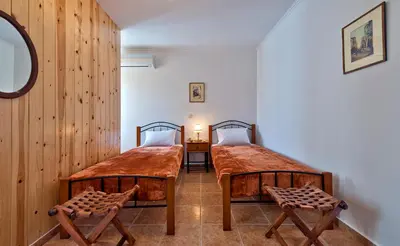 two twin beds in a room with wooden walls at Aphrodite House in Chania Town