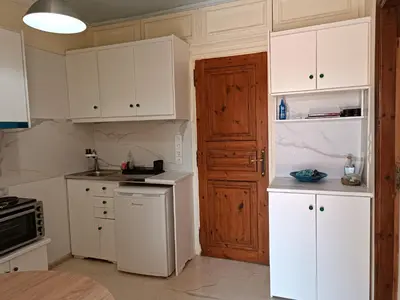 a kitchen with white cabinets and a white refrigerator at Rayon De Soleil in Chania Town
