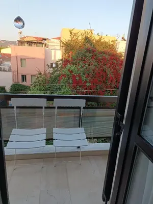 two white chairs sitting on a balcony with a window at Rayon De Soleil in Chania Town