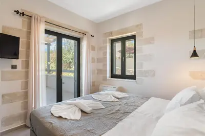 a bedroom with a bed with two pillows on it at Brand new Villa Volakas BY APOKORONAS VILLAS in Gavalochori