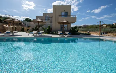 a large swimming pool in front of a house at Villaggio Mare Suites in Kalamaki Chanion