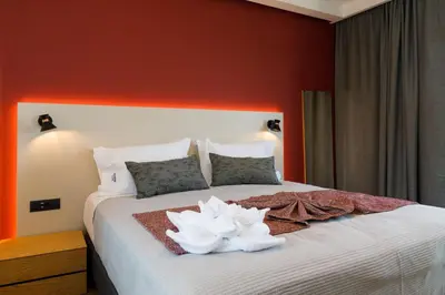 a bedroom with a large bed with red walls at Exquisite Crete Villa Villa Kleanthi 4 Bedroom Private Pool in Stalos