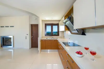 a kitchen with two glasses of wine on the counter at Iliada by Vintage Travel in Maleme