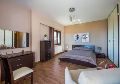 a large bedroom with a bed and a dresser at Iliada by Vintage Travel in Maleme