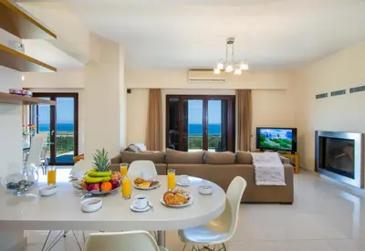 a living room with a table and a couch at Iliada by Vintage Travel in Maleme