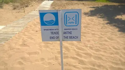 a sign in the sand in front of a beach at Zinovia in Kato Daratso