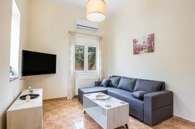 a living room with a blue couch and a tv at K_Kostas Apartment in Daratso