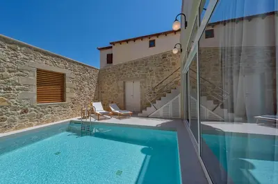 a villa with a swimming pool and a house at Hippocampo Waterfront Villa in Chania Town
