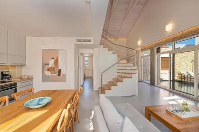 a kitchen and dining room with a table and a staircase at Hippocampo Waterfront Villa in Chania Town