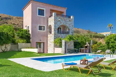 a villa with a swimming pool in front of a house at Villa Forteza in Kalami