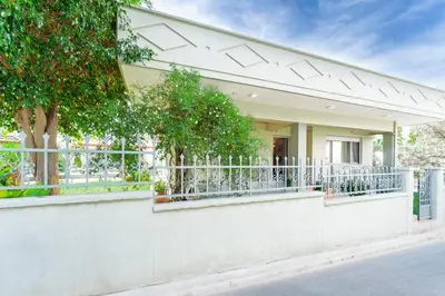 a house with a white fence and trees at Suncatcher House by 8essentially in Chania Town