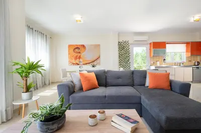 a living room with a blue couch and orange pillows at Geas House Ammos in Kolymvari