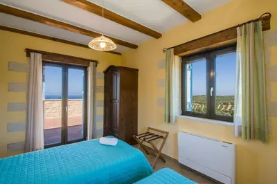 a bedroom with a bed and a window at Villa Aliki - Traditional stone house with maximum privacy and stunning views ! in Xamoudhokhórion