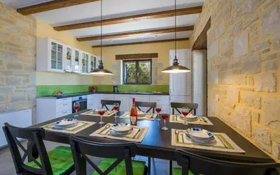a dining room with a table and chairs in a kitchen at Villa Aliki - Traditional stone house with maximum privacy and stunning views ! in Xamoudhokhórion