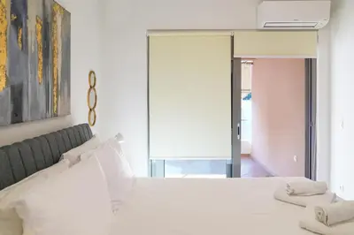 a bedroom with a white bed with white pillows at Aeri Home - At Nea Chora beach w. Parking included in Chania Town