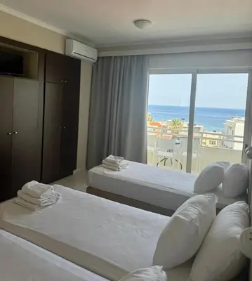 a hotel room with two beds and a view of the ocean at Kumba in Nea Chora in Chania Town