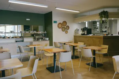 a restaurant with wooden tables and white chairs at Kumba in Nea Chora in Chania Town