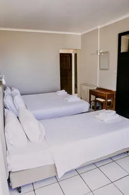 two beds in a hotel room with a table at Kumba in Nea Chora in Chania Town