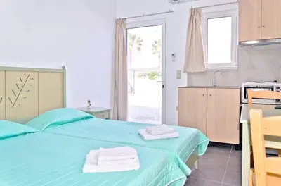 a bedroom with a blue bed with towels on it at On the Beach in Kissamos