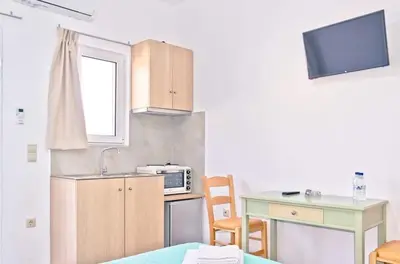 a small kitchen with a table and a microwave at On the Beach in Kissamos
