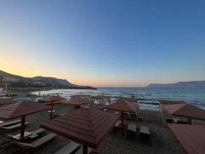 a group of tables and chairs on a beach at On the Beach in Kissamos