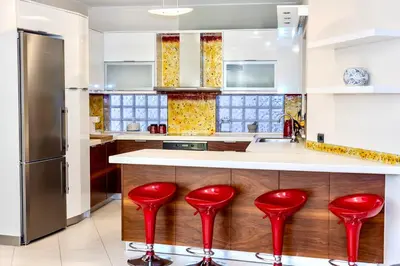 a kitchen with red stools in front of a counter at Seaty Luxury apartment in Chania Town