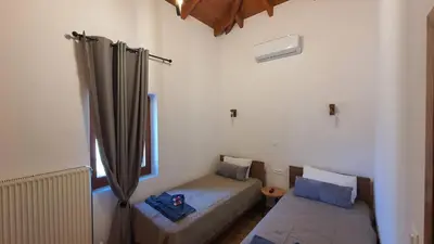 a small room with a bed and a window at Villa Anasa Residence in Varípetron