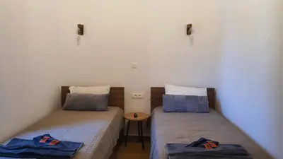 two twin beds in a room with a table at Villa Anasa Residence in Varípetron