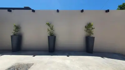 three black vases with plants in them on a wall at Villa Anasa Residence in Varípetron