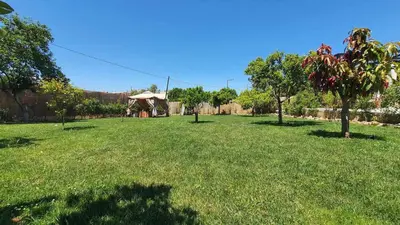a large grass field with trees and a gazebo at Villa Anasa Residence in Varípetron