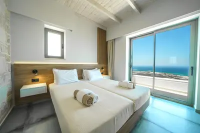 a bedroom with a large bed with a large window at NAFSIKA XENIA-VILLA ARGO in Plátanos