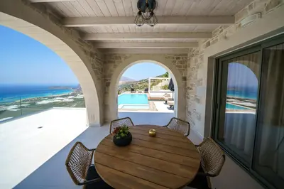 a dining room with a table and a view of the ocean at NAFSIKA XENIA-VILLA ARGO in Plátanos