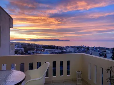 a sunset from a balcony with a table and chairs at Stephanie's Place - Charming Apartment with Sea View in Chania Town