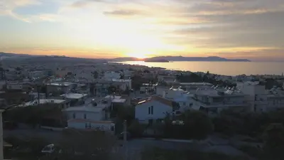 a view of a city with the sunset in the background at Stephanie's Place - Charming Apartment with Sea View in Chania Town