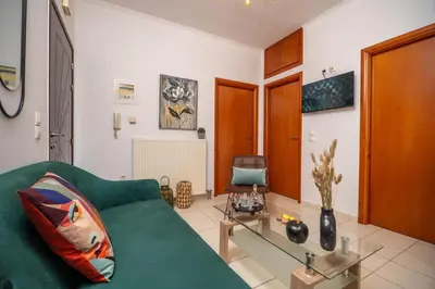 a living room with a green couch and a glass table at Ammoutsiani 2 Cozy Apartment by 8essentially in Chania Town