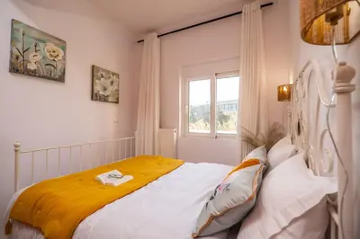 a bedroom with a bed with a yellow blanket at Ammoutsiani 2 Cozy Apartment by 8essentially in Chania Town