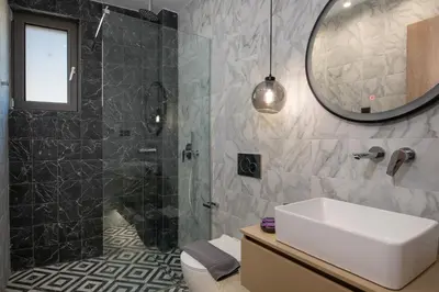 a bathroom with a sink and a shower with a mirror at ALPHA SUITES in Chania Town