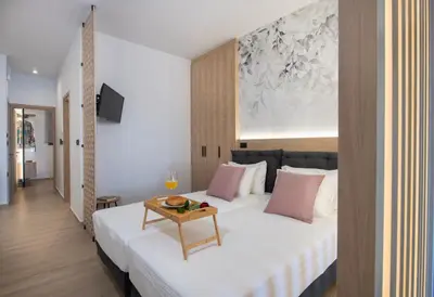 a bedroom with a large white bed with pink pillows at ALPHA SUITES in Chania Town