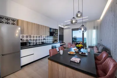 a kitchen and living room with a table and a refrigerator at ALPHA SUITES in Chania Town