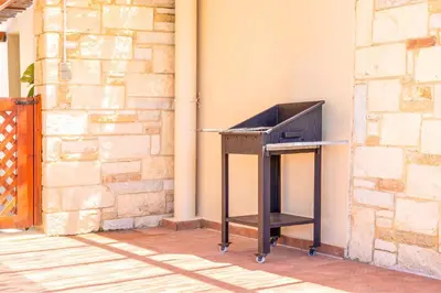 a desk with a television sitting next to a wall at Villa Portokalia Platanias in Plataniás