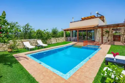 a swimming pool in the backyard of a house at Villa Lemonia Platanias in Plataniás