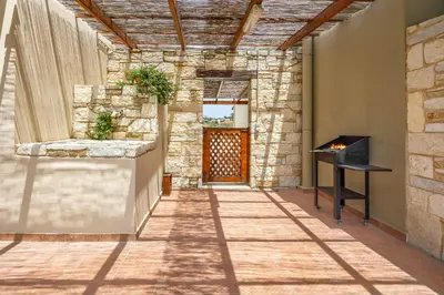 a hallway with a stone wall and a wooden door at Villa Lemonia Platanias in Plataniás