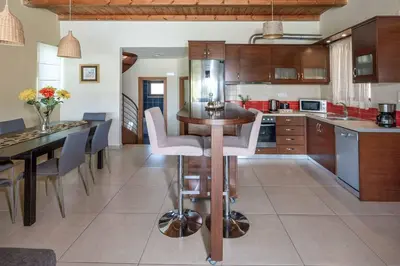 a kitchen with a table and chairs in a room at Villa Lemonia Platanias in Plataniás