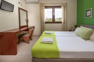 a bedroom with a desk and a bed with a green wall at Villa Lemonia Platanias in Plataniás