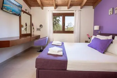 a bedroom with a large bed with purple accents at Villa Mandarin Platanias in Plataniás