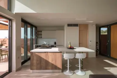 a kitchen with white countertops and a large island with bar stools at Casa Tarrha- Beachfront Villa with Heated Pool in Livadia