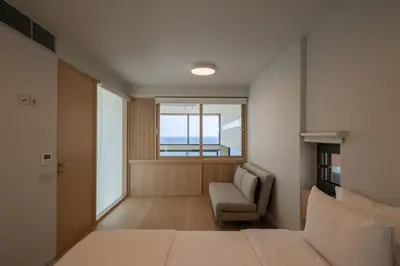 a bedroom with a bed and a chair and a window at Casa Tarrha- Beachfront Villa with Heated Pool in Livadia
