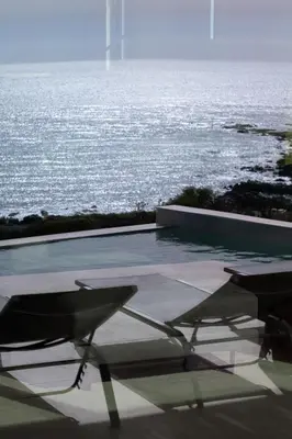 a swimming pool with chairs and a view of the ocean at Casa Tarrha- Beachfront Villa with Heated Pool in Livadia