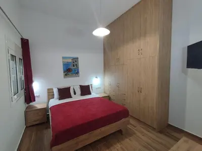 a bedroom with a large bed with a red blanket at Lenio's Apartment in Souda